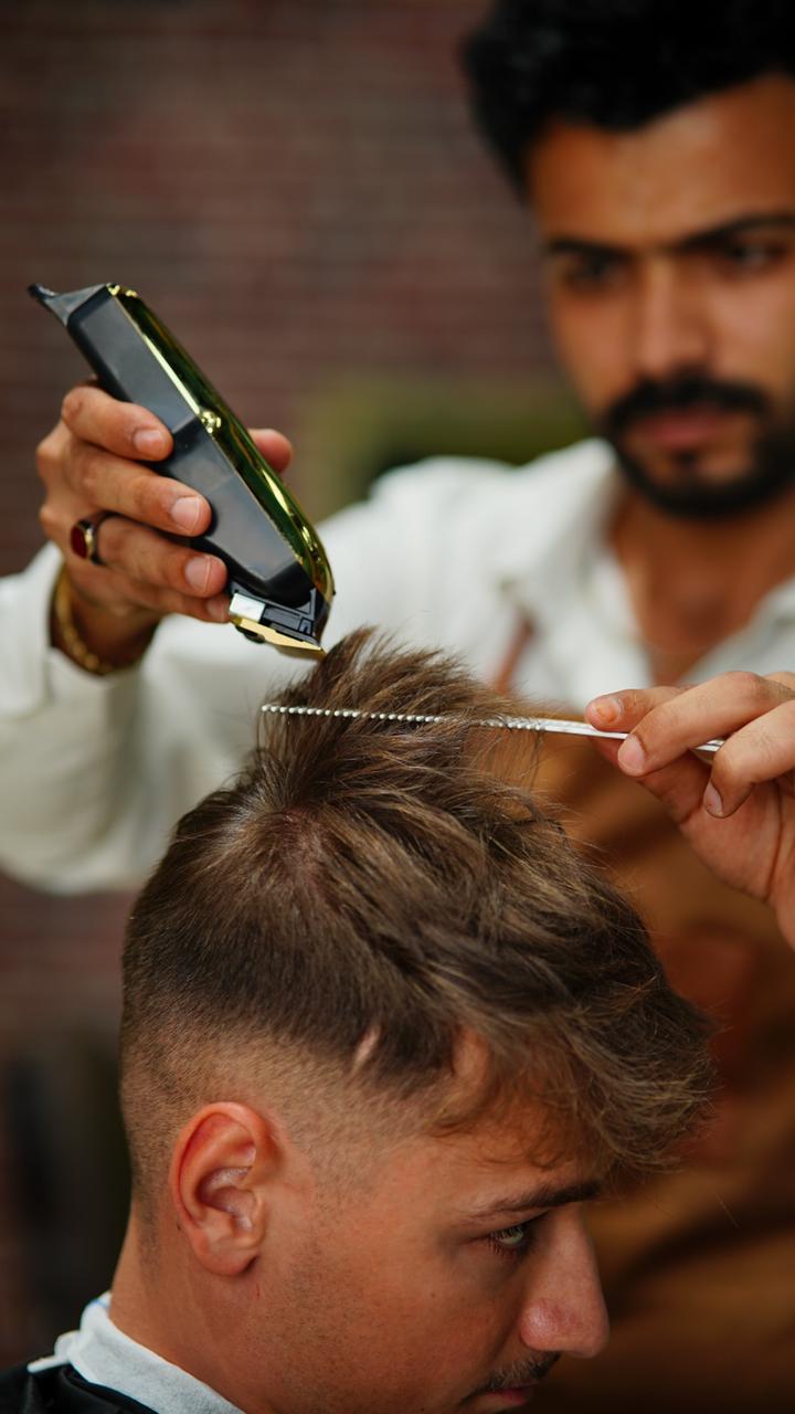 Clippers and a comb finishing a short cut