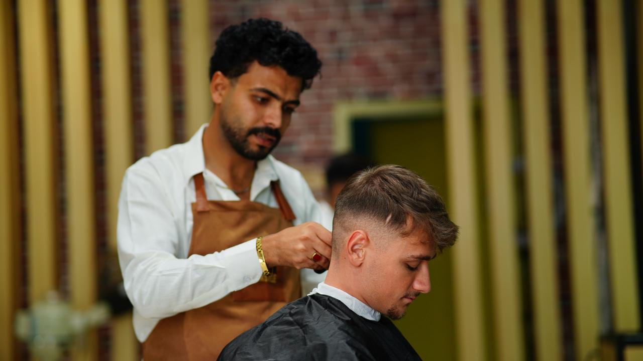 A barber cutting a client in the chair